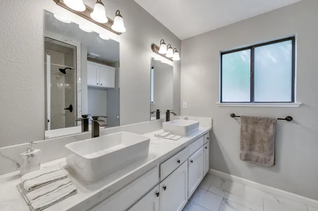a bathroom with double vanity sink and a mirror