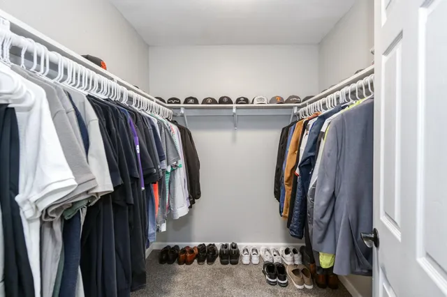 a view of walk in closet with clothes and shoes