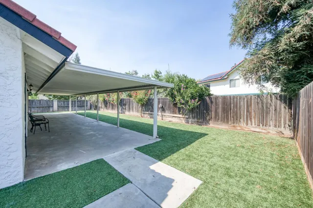 a view of a backyard with a garden and deck