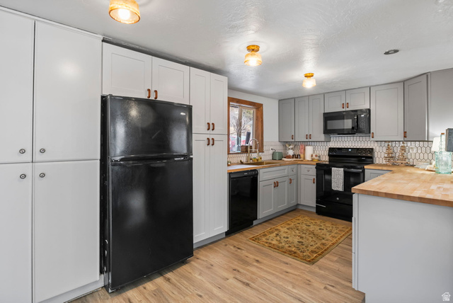 2189 Samak Park Loop, Unit 43 Kamas, UT 84036 - Photo 18 of 48 Kitchen with wood counters, black appliances, light wood finished floors, a textured ceiling, and gray cabinetry