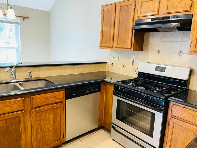 a kitchen with granite countertop cabinets and black appliances