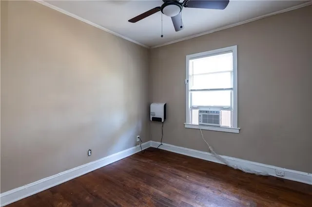 an empty room with a window and wooden floor