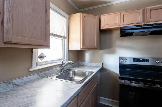 a kitchen with stainless steel appliances granite countertop a sink a stove and a microwave