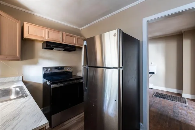 a kitchen with stainless steel appliances granite countertop a refrigerator and a sink