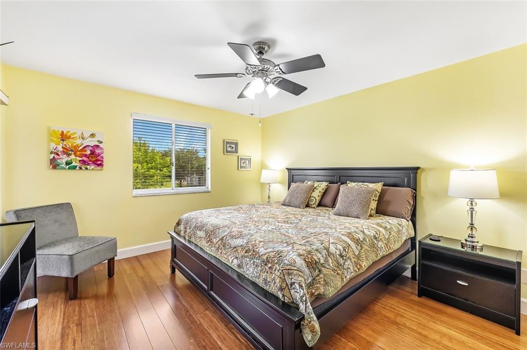 5695 Rattlesnake Hammock Road, Unit 202B Naples, FL 34113 - Photo 12 of 19 a bedroom with a bed and wooden floor