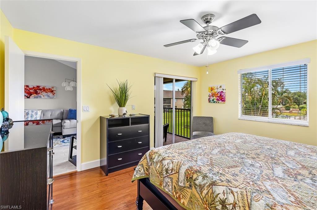 5695 Rattlesnake Hammock Road, Unit 202B Naples, FL 34113 - Photo 13 of 19 a bedroom with a bed and a chandelier