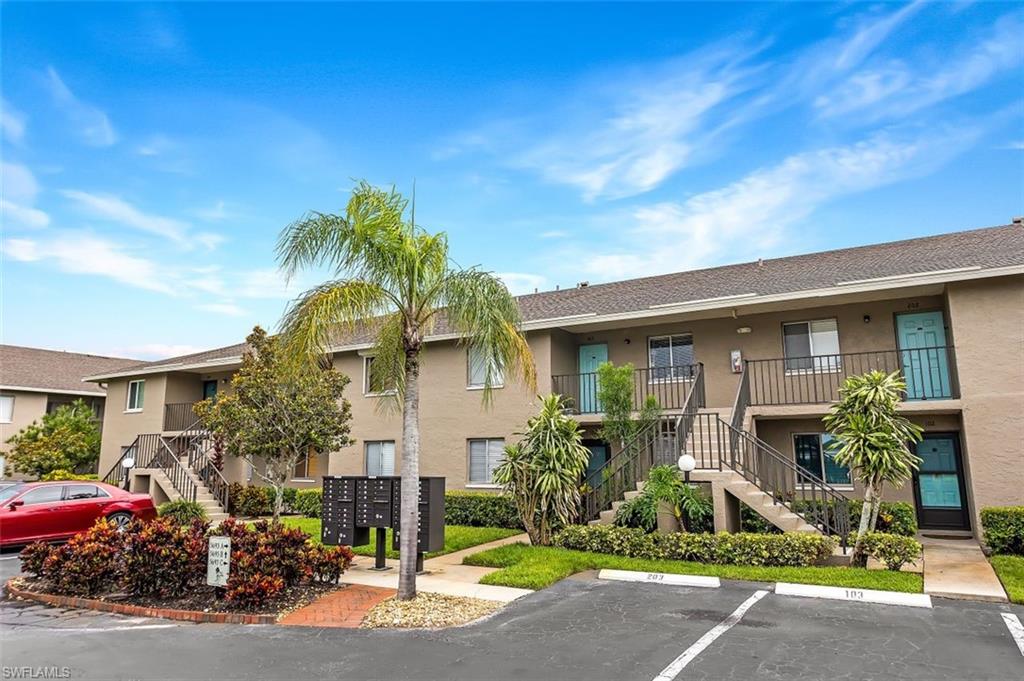 5695 Rattlesnake Hammock Road, Unit 202B Naples, FL 34113 - Photo 2 of 19 a front view of a house with garden