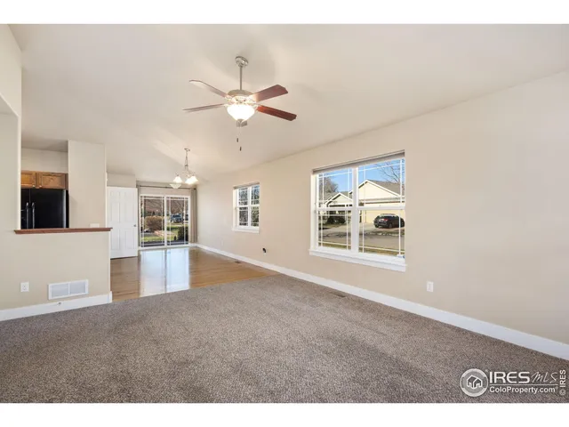 a view of an empty room and kitchen view