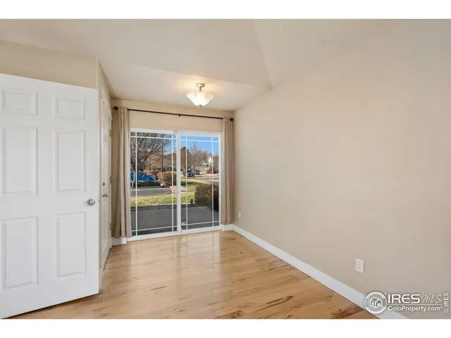 a view of a kitchen with kitchen island granite countertop wooden floor stainless steel appliances and a window