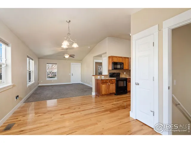 a kitchen with stainless steel appliances granite countertop a stove a sink and a refrigerator with wooden floor