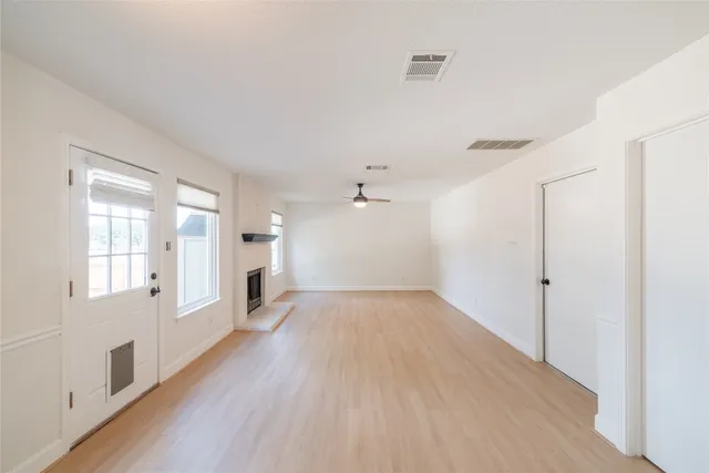 a view of a big room with wooden floor and windows