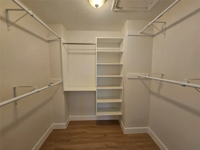 a view of walk in closet with empty racks