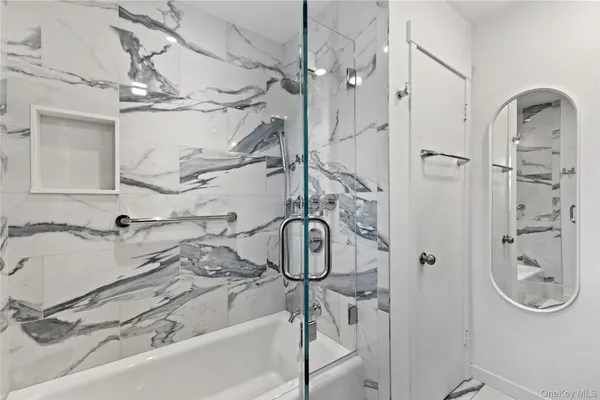 a bathroom with a tub sink and mirror