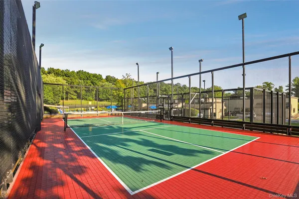 a view of a tennis ground with large trees