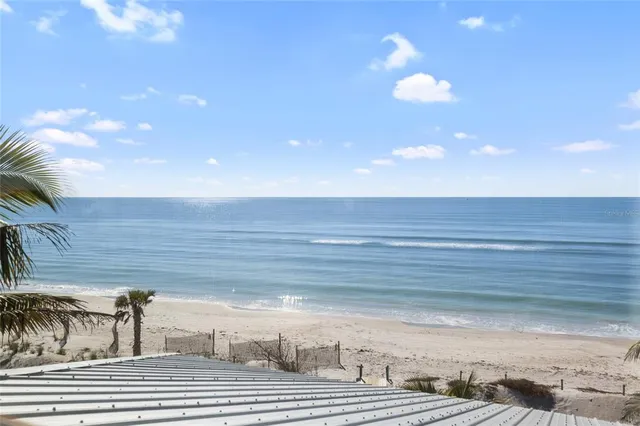 a view of swimming pool with seating space and trees in the background