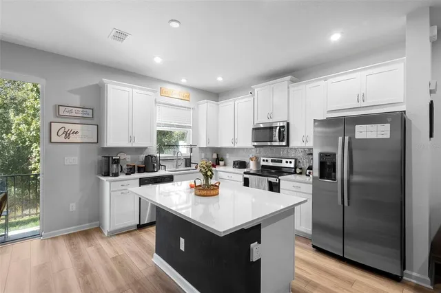 a kitchen with a stove a refrigerator a sink and dishwasher with wooden floor