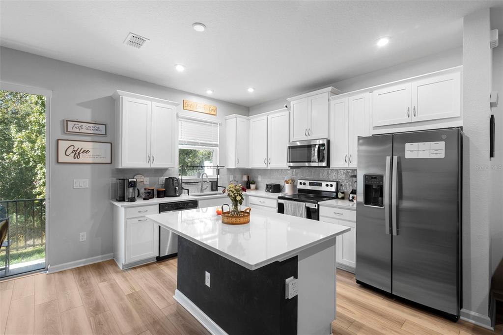 866 Spring Palms Loop Orlando, FL 32828 - Photo 4 of 26 a kitchen with a stove a refrigerator a sink and dishwasher with wooden floor