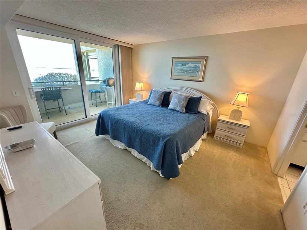 5915 Sea Ranch Drive, Unit 711 Hudson, FL 34667 - Photo 17 of 85 a spacious bedroom with a bed and glass door