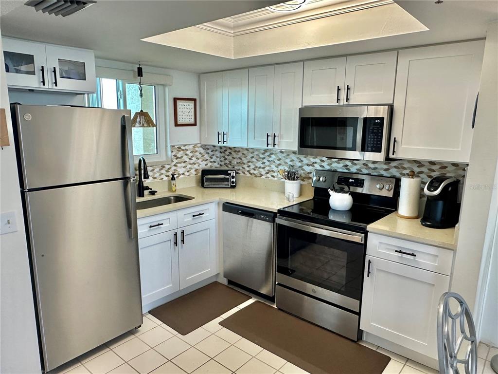 5915 Sea Ranch Drive, Unit 711 Hudson, FL 34667 - Photo 7 of 85 a kitchen with stainless steel appliances a refrigerator sink and microwave
