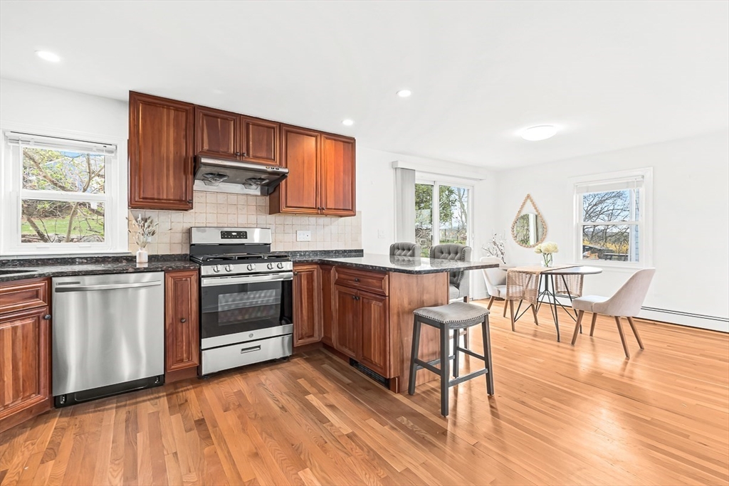 104 Wendell Street Winchester, MA 01890 - Photo 13 of 42 a kitchen with stainless steel appliances a stove a sink dishwasher and microwave with wooden floor