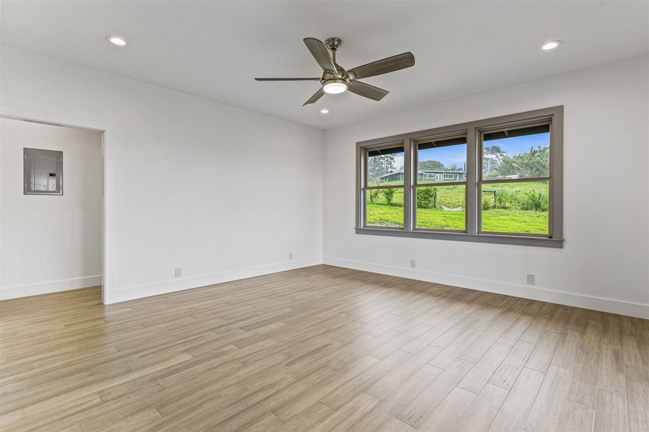 780 West Kuiaha Road Haiku, HI 96708 - Photo 19 of 30 a view of an empty room with wooden floor and a window