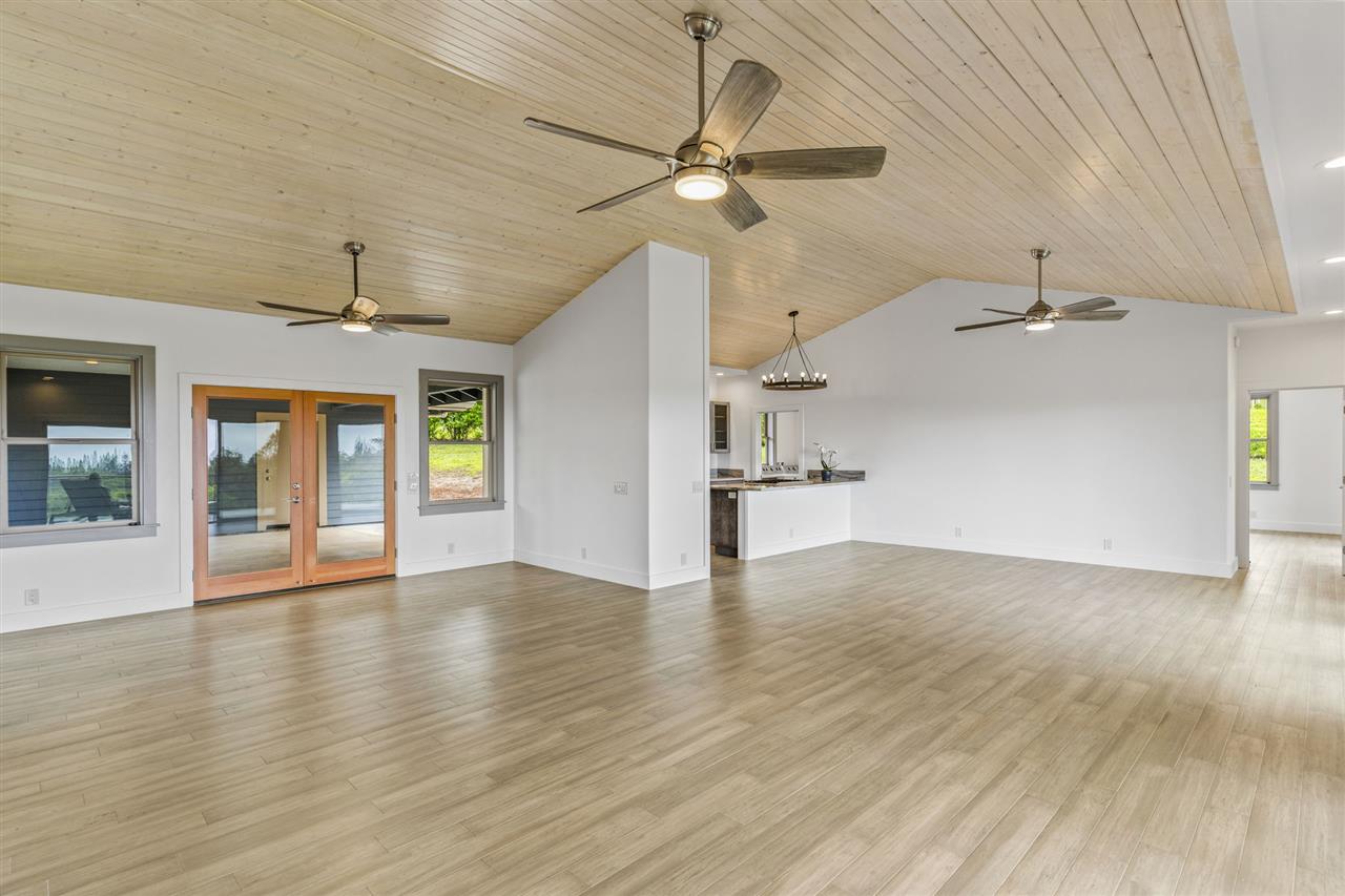 780 West Kuiaha Road Haiku, HI 96708 - Photo 10 of 30 an empty room with wooden floor ceiling fan and windows