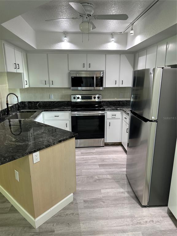 6967 Crown Drive, Unit B Englewood, FL 34224 - Photo 3 of 16 a kitchen with stainless steel appliances granite countertop a sink stove and refrigerator