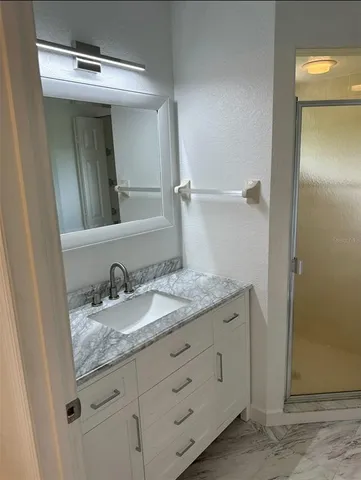 a bathroom with a granite countertop sink and a mirror