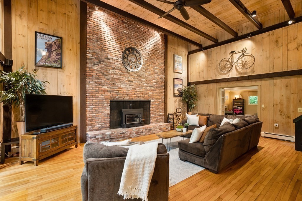 153 Green Road Bolton, MA 01740 - Photo 4 of 42 a living room with furniture a flat screen tv and a fireplace