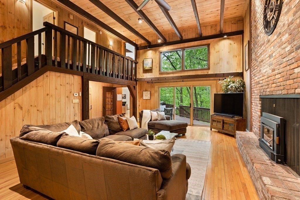 153 Green Road Bolton, MA 01740 - Photo 6 of 42 a living room with furniture a flat screen tv and a fireplace