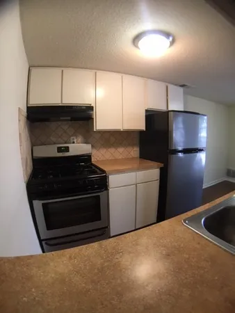 a kitchen with a refrigerator and a stove