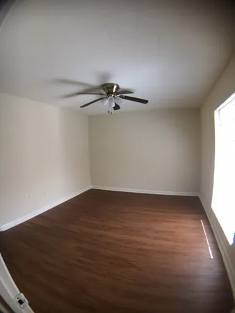 a view of a room with wooden floor cabinet and a ceiling fan