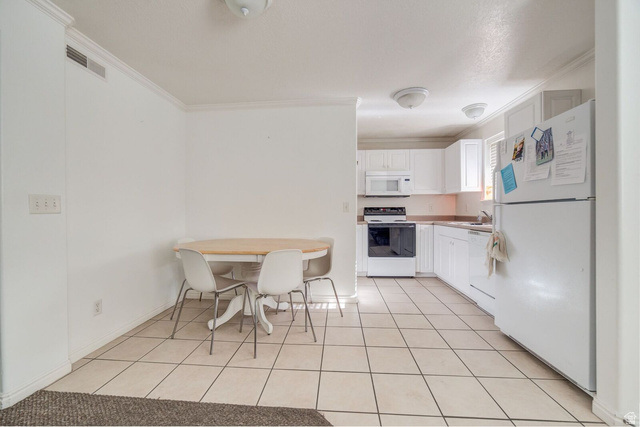 72 300 North, Unit 302 Provo, UT 84601 - Photo 3 of 16 Kitchen and dining area featuring white cabinetry, white appliances, and tiled flooring