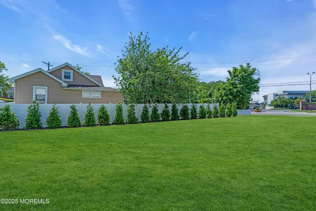 an aerial view of residential houses with outdoor space and trees