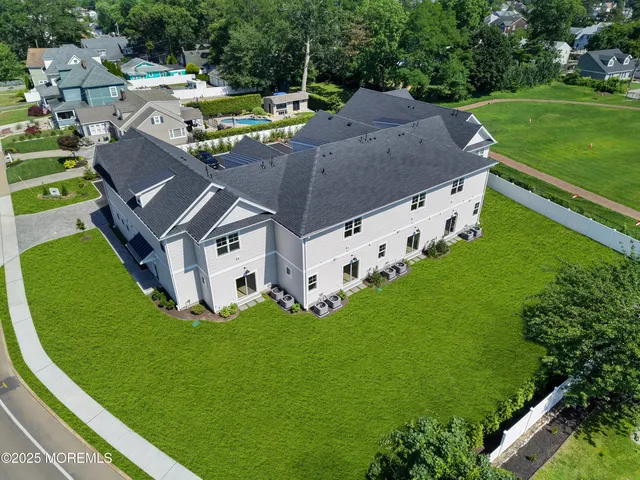 an aerial view of residential houses with outdoor space and street view