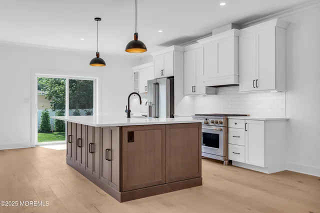 a kitchen with stainless steel appliances granite countertop a sink a stove and a refrigerator