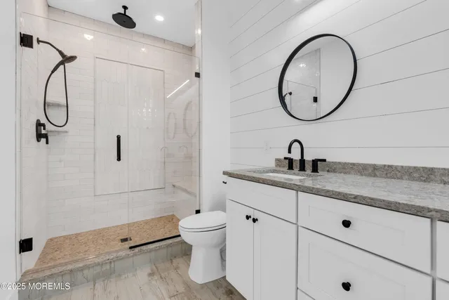 a bathroom with a granite countertop sink a toilet and a mirror
