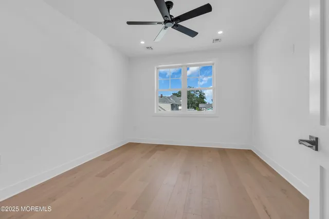 an empty room with a window and a ceiling fan