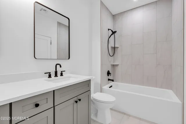 a view of a big room with wooden floor a ceiling fan and windows