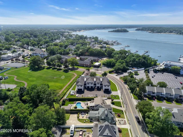 an aerial view of residential houses with outdoor space and trees