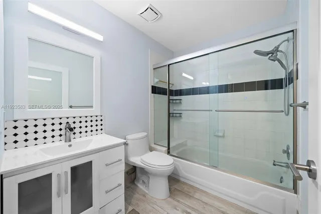a view of a livingroom with wooden floor and a flat screen tv