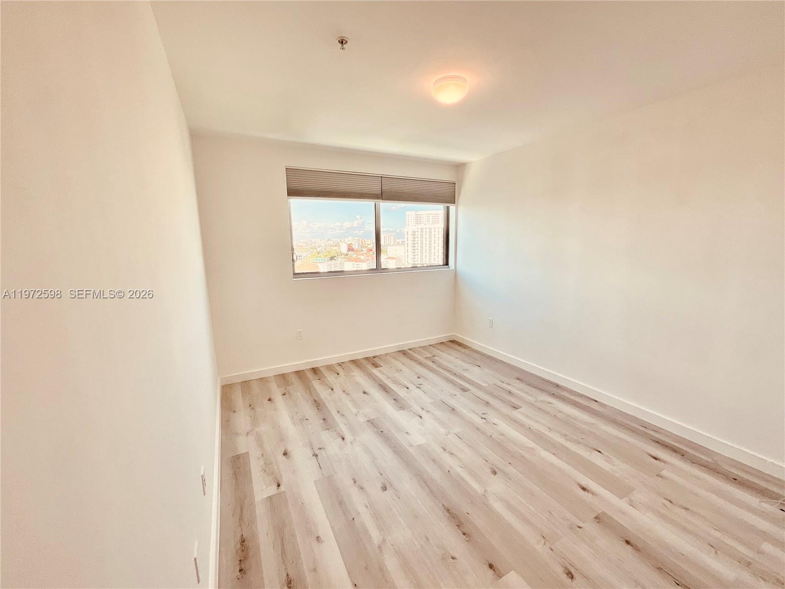 1600 Southwest 1st Avenue, Unit 1204 Miami, FL 33129 - Photo 56 of 75 an empty room with wooden floor and windows