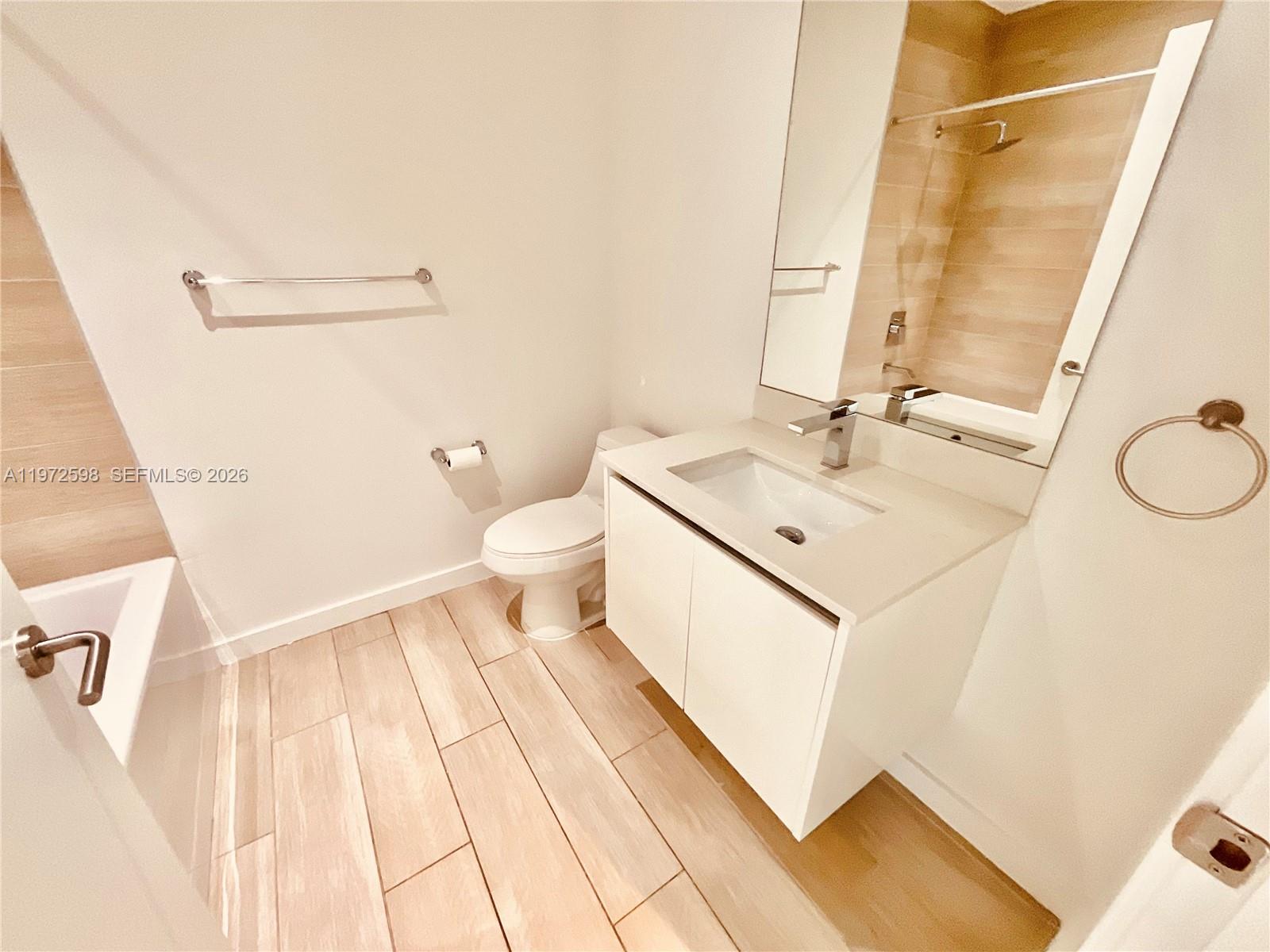 1600 Southwest 1st Avenue, Unit 1204 Miami, FL 33129 - Photo 58 of 75 a bathroom with a sink a toilet and a mirror