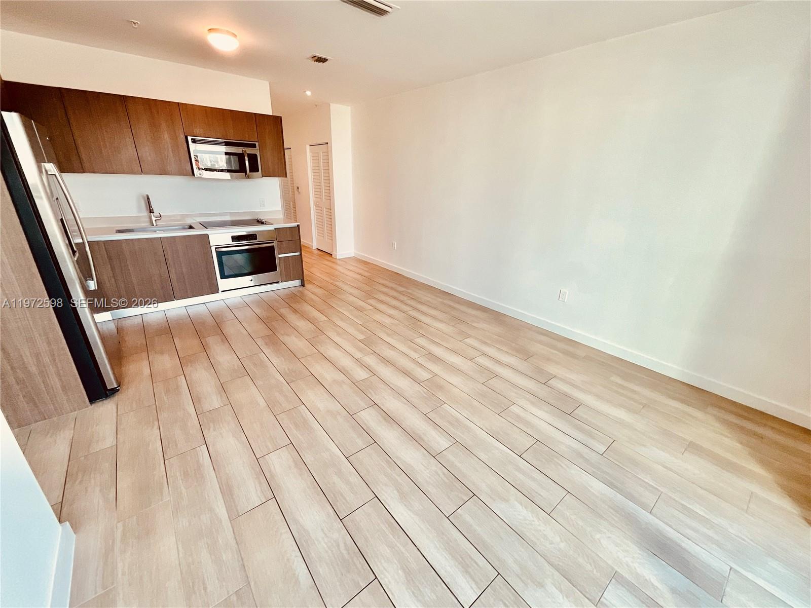 1600 Southwest 1st Avenue, Unit 1204 Miami, FL 33129 - Photo 62 of 75 a view of kitchen with stainless steel appliances wooden floor and a refrigerator
