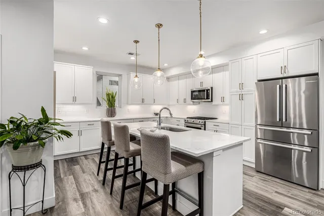 a kitchen with granite countertop a table chairs stove a sink and dishwasher