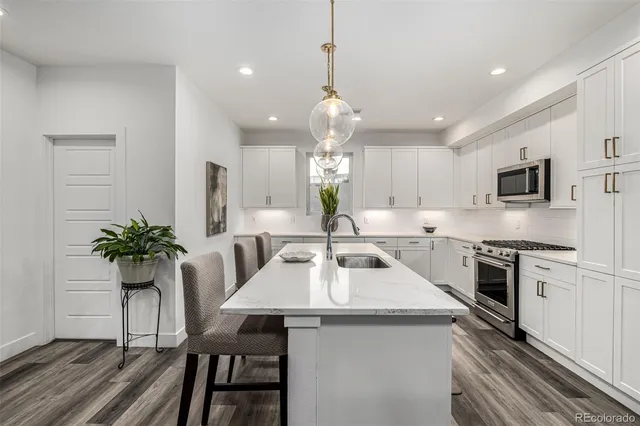 a kitchen with white cabinets and stainless steel appliances