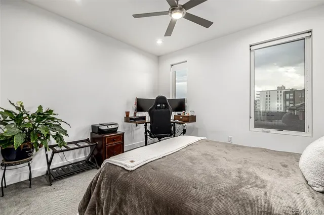 a bedroom with a bed and a computer on a desk