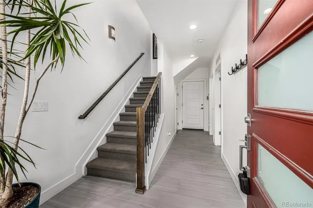 a view of a hallway with wooden floor and stairs