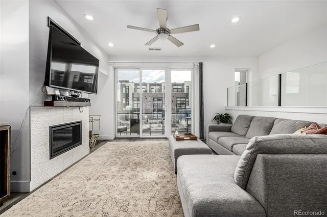 a living room with furniture a flat screen tv and a fireplace