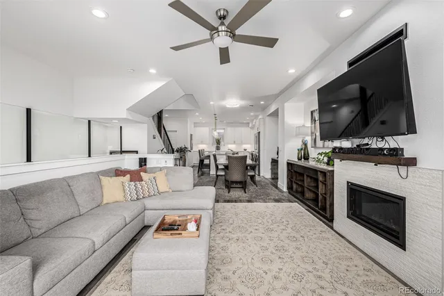 a living room with furniture and a flat screen tv with kitchen view